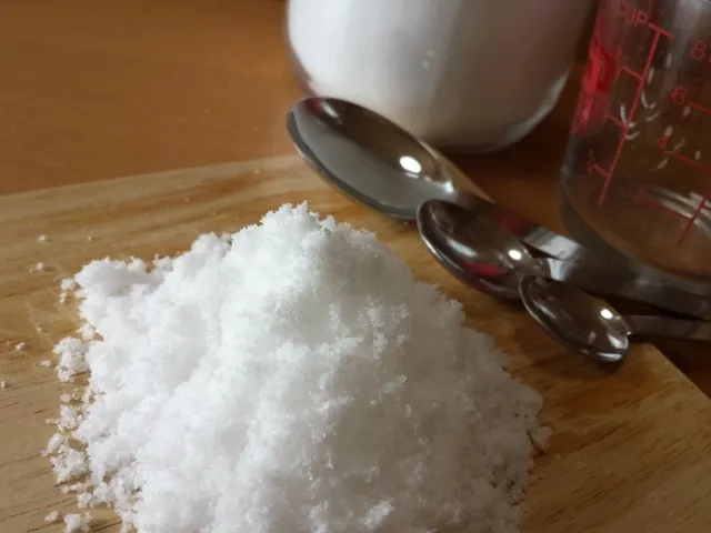 減塩のためまな板の上に盛られた塩を大中小の計量スプーンで計ろうとする所