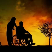 日が沈む様子を眺める車椅子の男性と車椅子を押すミッシングワーカーの女性
