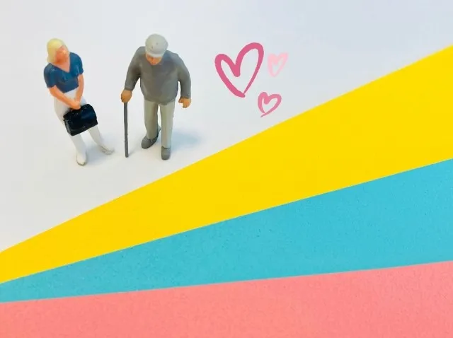 介護の日に高齢者と介護者が黄色、青、赤のラインを立って見つめる